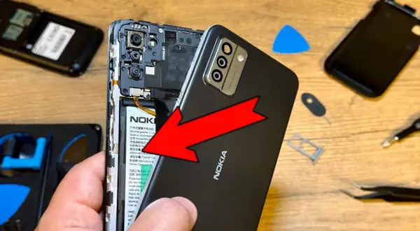 Wymiana baterii w telefonie Nokia. Czy przy wymianie baterii resetuje telefon? Narzędzia do naprawy leżą obok.