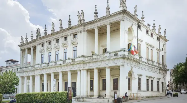 Prachtvolles Gebäude im Stil der Manierismus Architektur, mit Säulen, Statuen und italienischen Flaggen.
