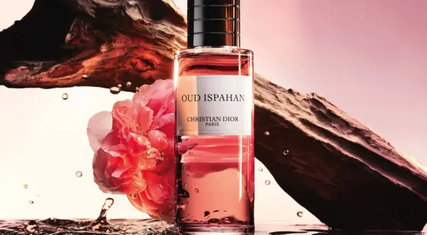 Flakon Dior Oud Ispahan otoczony wodą, różą i fragmentem drewna.