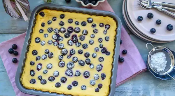 Frisch gebackener Blaubeer-Käsekuchen, bestäubt mit Puderzucker, bereit zum Servieren.
