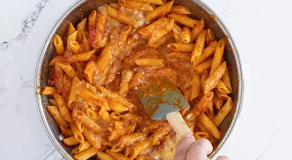 Macarrones con huevo y salsa de tomate en sartén, listos para servir.