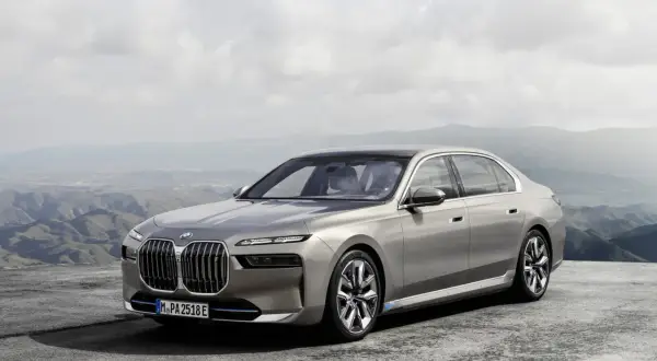 Elegancki, szary sedan BMW 7 2025 na tle górskiego krajobrazu.