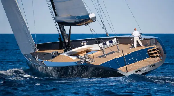 Il Wally Esense naviga con vele spiegate, un uomo al timone. Lusso e velocità sull'onda blu.