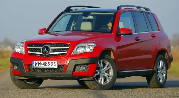 Czerwony Mercedes GLK na drodze. Kierowca w środku. Wiele osób szuka mercedes glk opinie przed zakupem.