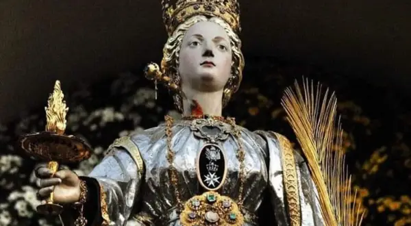 Święta Łucja, patronka niewidomych, trzyma płonącą lampę. Jej imię oznacza "światło", co oznacza imię Łucja.
