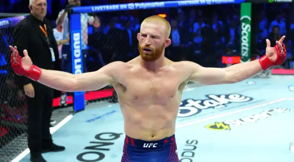 En utmattad Santiago Ponzinibbio med armarna utsträckta i oktagonen, redo för nästa utmaning.