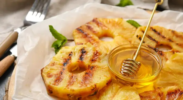 Złocisty, grillowany ananas z miodem i miętą, gotowy do podania.