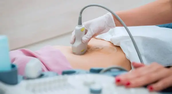 Lekarz wykonuje USG jamy brzusznej, badanie to może pomóc odpowiedzieć na pytanie, czy usg jamy brzusznej wykryje raka.