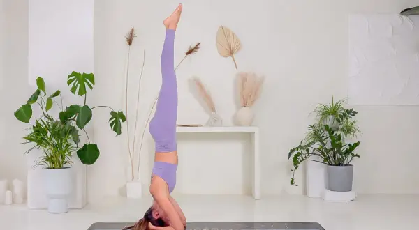 Donna in posa di Sirsasana, una delle inversioni yoga più conosciute.