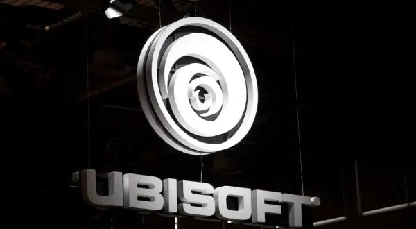 Jasne, oto opis alternatywny:

Podświetlone logo Ubisoft i nazwa firmy wiszą w ciemnym pomieszczeniu. To świetna reklama dla fanów gier Ubisoft akcje.