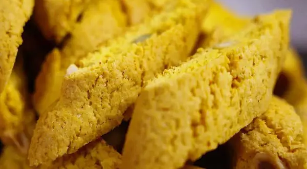 Närbild på gyllene saffransbiscotti med mandel, perfekta att doppa i kaffe.