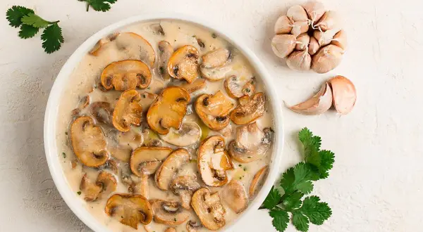 Krämig svampgryta, perfekt för ett snabbt champinjoner recept. Serveras med vitlök och färsk koriander.