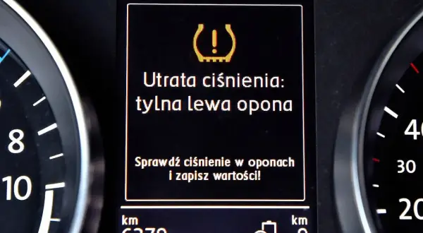 Komunikat na desce rozdzielczej: "Utrata ciśnienia: tylna lewa opona". Czujnik ciśnienia w oponach sygnalizuje problem.