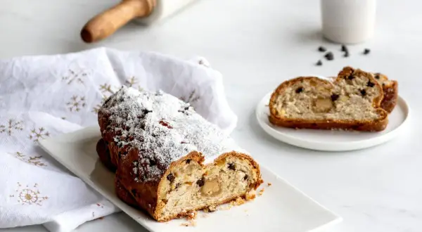 Un délicieux gâteau de Noël, saupoudré de sucre glace, semble avoir été volé, avec une part coupée et servie sur une assiette.