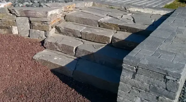 Kamienne schody i murek z kamienia łupanego tworzą naturalny element ogrodu.