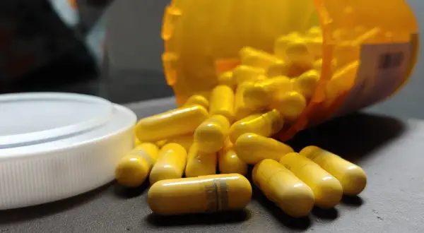 Gula kapslar, en del av en burk, ligger utspridda. En kapsel visar texten "gabapentin 300 mg", en medicin som kan hjälpa mot ångest.