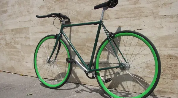 Bici da corsa verde con cerchi vivaci, un esempio di vernice per bici a pennello che risalta.