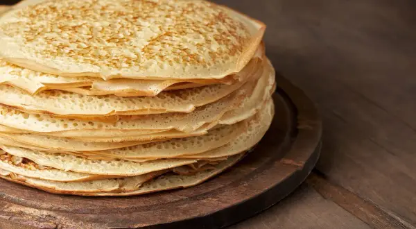 En hög med gyllene pannkakor med havregryn, perfekt för en mysig frukost eller fika.