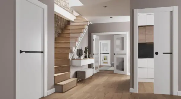 Instalar puerta corredera moderna en un recibidor con escaleras de madera y cocina visible.
