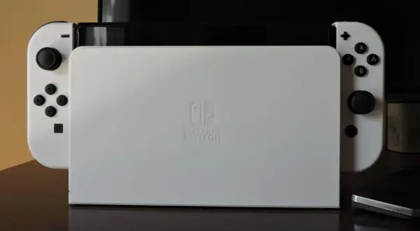 Biała konsola Nintendo Switch z dokiem do podłączenia do TV.