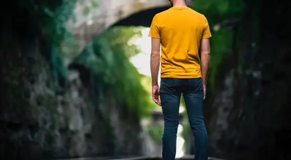 Man op spoor, omringd door groen. Een metafoor voor het navigeren door het leven met hsp, waar elke stap bewust gezet moet worden.