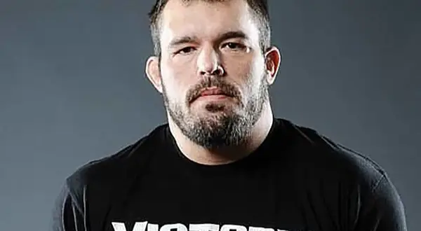 Dean Lister, en tuff MMA-fighter med skägg och en svart t-shirt med texten "Victory MMA & Fitness".