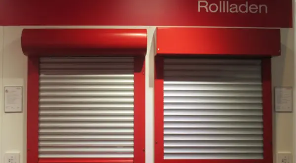 Dwie czerwone rolety zewnętrzne z aluminiowymi lamelami, prezentujące rozwiązania do ocieplenia domu.