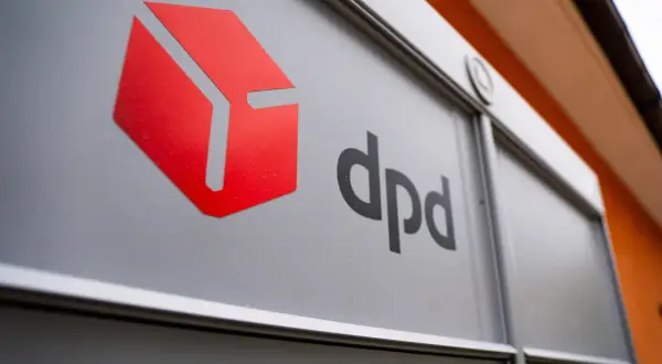 DPD przesyłka niedoręczona, odbiorca nieobecny. Znak DPD na szarej powierzchni.