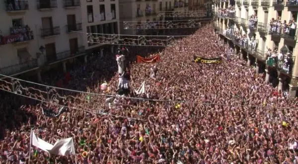 Multitudinaria plaza de Teruel, con gente en balcones y calles, celebrando el chupinazo.
