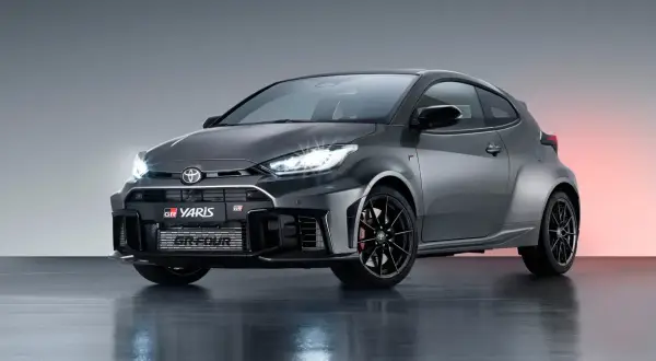 Szary Toyota GR Yaris z czarnymi felgami i czerwonymi zaciskami hamulcowymi, gotowy do akcji.