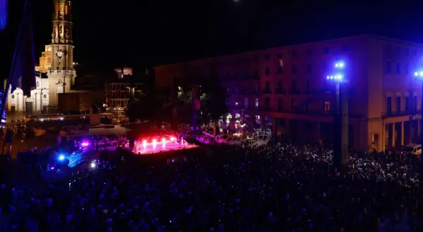 Multitud celebra la **noche blanca Zaragoza** ante un escenario iluminado y la Basílica del Pilar.