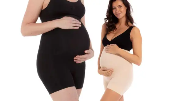 Dos mujeres embarazadas muestran ropa premamá. Descubre cuándo usar ropa premamá para mayor comodidad y soporte.