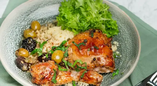 En härlig tallrik med kyckling, couscous, oliver och sallad. Ett perfekt medelhavskost recept kyckling för en smakrik måltid.