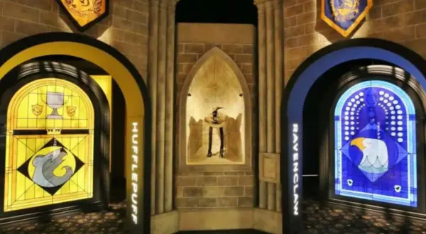 Wystawa Harry Potter: witraże Hufflepuff i Ravenclaw, a w centrum figura z kapeluszem.