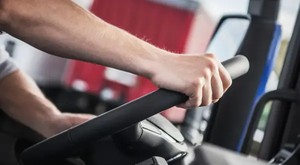 Main d'un conducteur sur le volant d'un camion. La question "carte fimo c'est quoi" pourrait être posée par quelqu'un qui apprend ce métier.