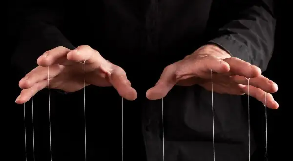 Dłonie trzymające nitki marionetki. Czas na zemstę na manipulancie, który myślał, że ma kontrolę.