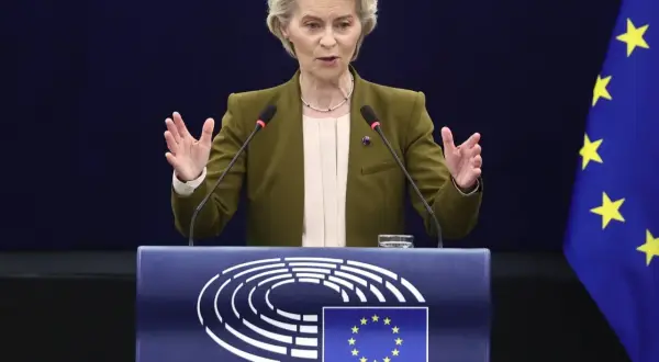 Ursula von der Leyen przemawia przy mównicy z logo Parlamentu Europejskiego i flagą UE.