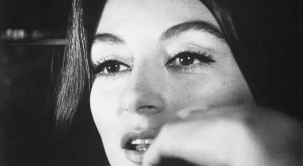 Nahaufnahme von Anouk Aimée, deren Blick nachdenklich ist. Sie erinnert an eine vergangene Liebe, vielleicht ihren Ehepartner.