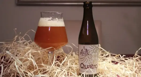 Szklanka i butelka piwa Pinta Quatro Special Double IPA. To jest właśnie IPA, czyli India Pale Ale, piwo o intensywnym chmielowym aromacie.