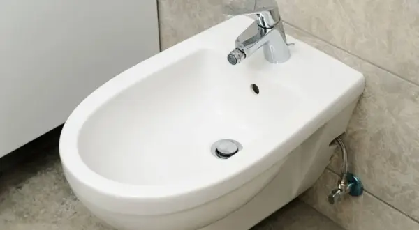Bidet bianco in ceramica con rubinetto cromato. Se il tuo bidet è otturato, ecco come sturare il bidet in modo efficace.