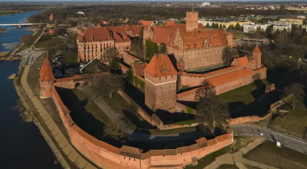 Potężny zamek w Malborku, z czerwonej cegły, otoczony murami obronnymi i fosą. Wspaniałe widoki, które potwierdzają pozytywne opinie o tym miejscu.