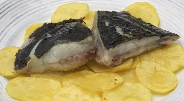 Rodaballo a la plancha servido sobre patatas fritas crujientes. Un plato sencillo y delicioso.