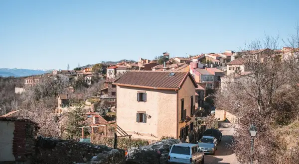 Casas de piedra y tejados rojos en un pueblo de montaña, hogar de los **habitantes Montejo de la Sierra**.