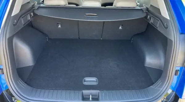 Pusty bagażnik Kia Sportage, gotowy na wakacyjne wyjazdy. Wygodny dostęp i spora przestrzeń.