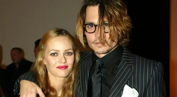Johnny Depp i Vanessa Paradis na gali. Johnny w okularach i garniturze w paski, Vanessa z błyszczącymi ustami.
