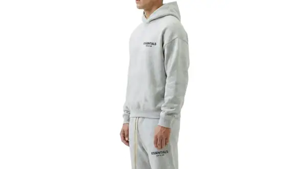 Szary komplet Essentials z kapturem i spodniami dresowymi. Zastanawiasz się, ile waży bluza Essentials? Jest lekka i wygodna.