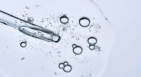 Kropla serum z pipetką, bąbelki unoszące się w żelu. Czy peptydy można łączyć z witaminą C? To pytanie nurtuje wiele osób dbających o cerę.