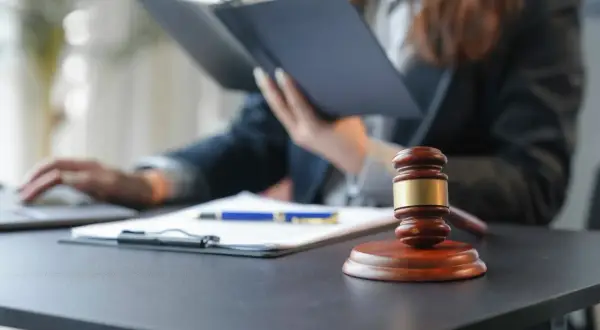 Sądowy młotek i dokumenty na biurku. Zastanawiasz się, ile kosztuje pełnomocnictwo notarialne?