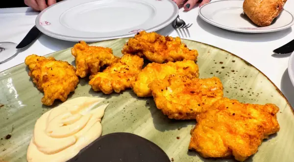 Crujientes fritos de pixin dorados, servidos con una cremosa salsa y un toque de oscuridad. ¡Un manjar para disfrutar!