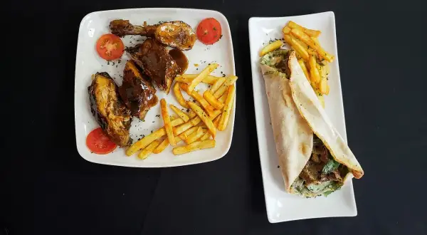 Dwa talerze z jedzeniem: żeberka w sosie z frytkami i pomidorkami, oraz wrap z mięsem i frytkami. Pytanie: halal co to?